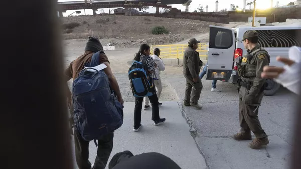 Migrantes se dirigen a una camioneta de la Patrulla Fronteriza tras cruzar irregularmente la frontera estadounidense (archivo) - Sputnik Mundo