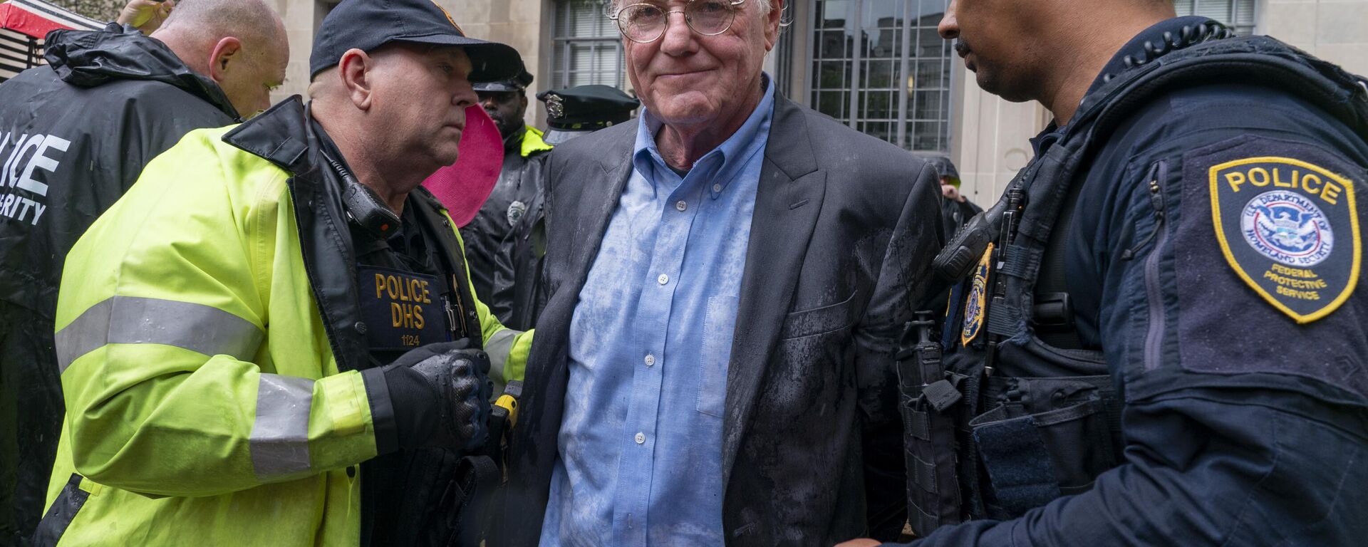 Ben Cohen, cofundador de Ben & Jerry's (centro), siendo arrestado por la Policía del Departamento de Seguridad Nacional por bloquear la entrada al Departamento de Justicia, tras quemar una réplica de la Carta de Derechos en protesta por el procesamiento del fundador de Wikileaks, Julian Assange (archivo) - Sputnik Mundo, 1920, 15.05.2025