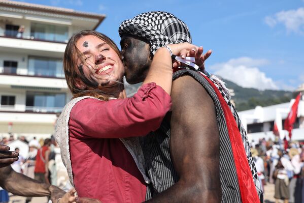 Dos personas durante la lucha de moros y cristianos del Es Firó de Sóller en la playa de Can Generós, en Sóller, Mallorca, Islas Baleares, España. Durante esta celebración se representa la batalla que tuvo lugar cuando los moros invadieron el Puerto de Sóller en mayo de 1561. La representación comienza en el puerto y avanza hacia el pueblo, terminando en la plaza mayor, con la celebración de la victoria de los cristianos. - Sputnik Mundo