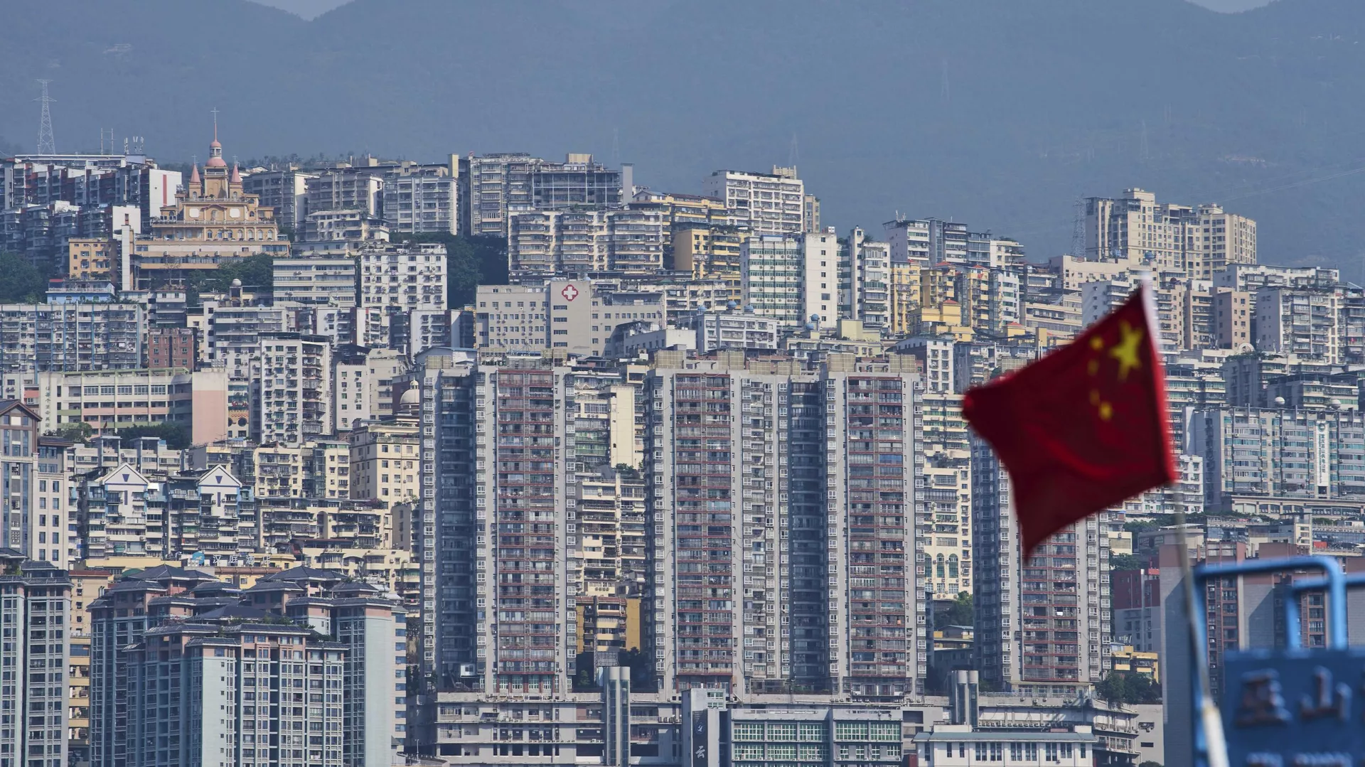 Una bandera nacional china ondea frente a los altos edificios residenciales del condado de Wushan, en la municipalidad de Chongqing, suroeste de China, el miércoles 21 de mayo de 2025. (Foto AP/Andy Wong) - Sputnik Mundo, 1920, 24.05.2025