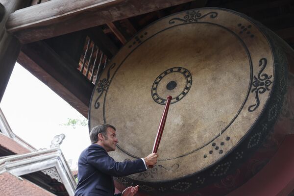 El presidente francés Emmanuel Macron toca el tambor en el templo Van Mieu de Hanói durante su primera visita oficial a Vietnam. - Sputnik Mundo