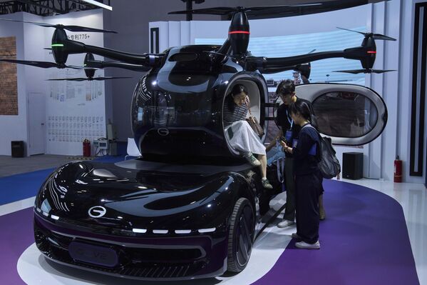 Visitantes observando el Govy AirCar, aeronave eléctrica de despegue y aterrizaje vertical (eVTOL) en una feria de tecnología y educación en China. - Sputnik Mundo