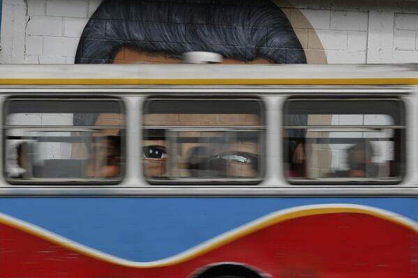 Un autobús urbano pasa junto a un mural con la imagen del presidente de Venezuela, Nicolás Maduro, en Caracas. Un autobús urbano pasa junto a un mural con la imagen del presidente de Venezuela, Nicolás Maduro, en Caracas. - Sputnik Mundo