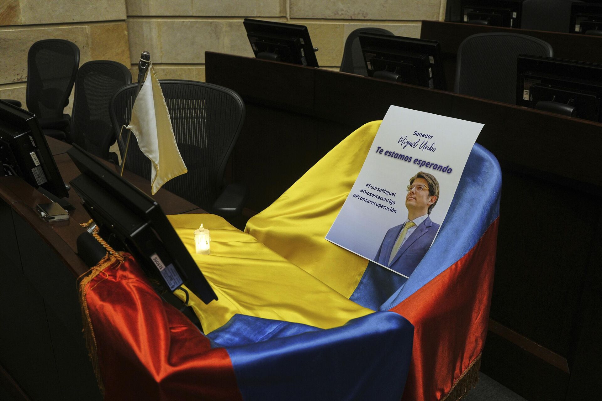 Un retrato del senador Miguel Uribe Turbay sobre una bandera colombiana en su asiento en el Congreso de Colombia - Sputnik Mundo, 1920, 10.06.2025
