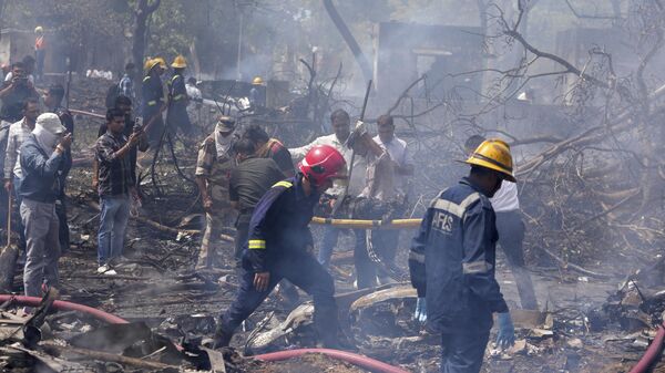 Los bomberos trabajan en el lugar donde se estrelló un avión en la ciudad india de Ahmedabad, en el estado de Gujarat, el  12 de junio de 2025 - Sputnik Mundo
