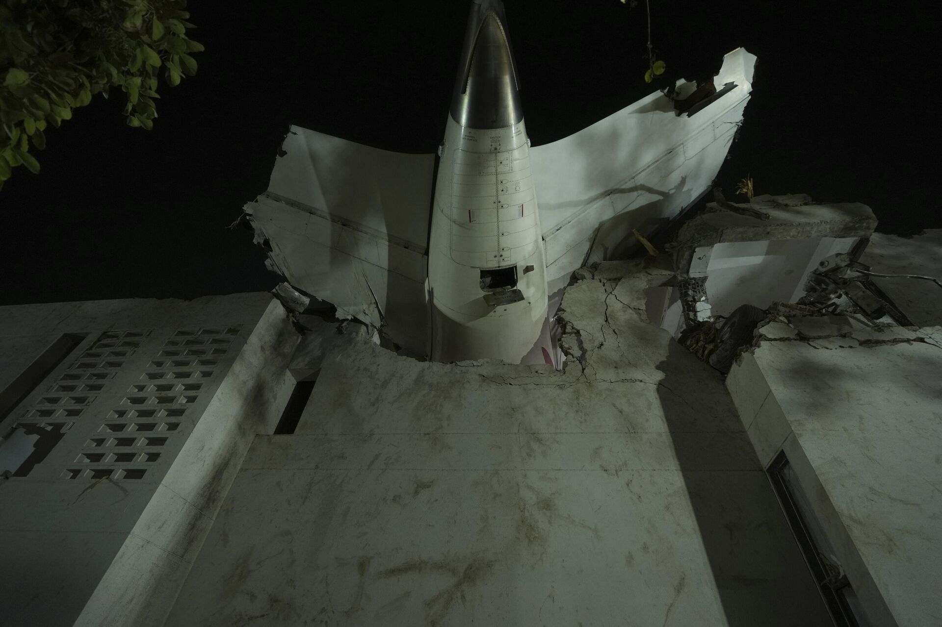 La cola del avión se ve atascada en un edificio en el lugar de un avión que se estrelló en la ciudad noroccidental india de Ahmedabad, en el estado de Gujarat, India, - Sputnik Mundo, 1920, 12.06.2025