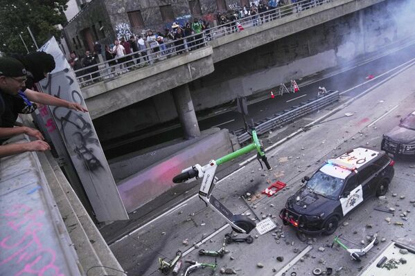 Un manifestante lanza un patinete eléctrico contra un vehículo policial cerca del centro de detención en la ciudad estadounidense de Los Ángeles. - Sputnik Mundo