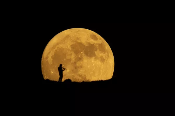 Una persona tocando el violín bajo la luz de la luna llena que se eleva sobre la ciudad iraquí de Halabja. Una persona tocando el violín bajo la luz de la luna llena que se eleva sobre la ciudad iraquí de Halabja. - Sputnik Mundo