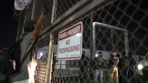 Un manifestante grita a agentes federales dentro del Centro de Detención Delaney Hall durante las protestas contra las redadas de inmigración el jueves 12 de junio de 2025 en Newark, Nueva Jersey. (Foto AP/Olga Fedorova) - Sputnik Mundo