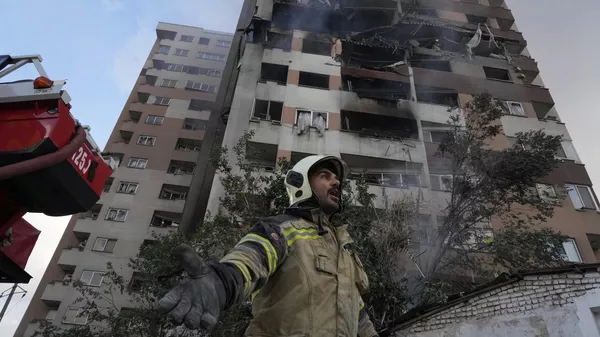 Un bombero llama a sus colegas en la escena de una explosión en un complejo residencial en el norte de Teherán, Irán, 13 de junio de 2025 - Sputnik Mundo