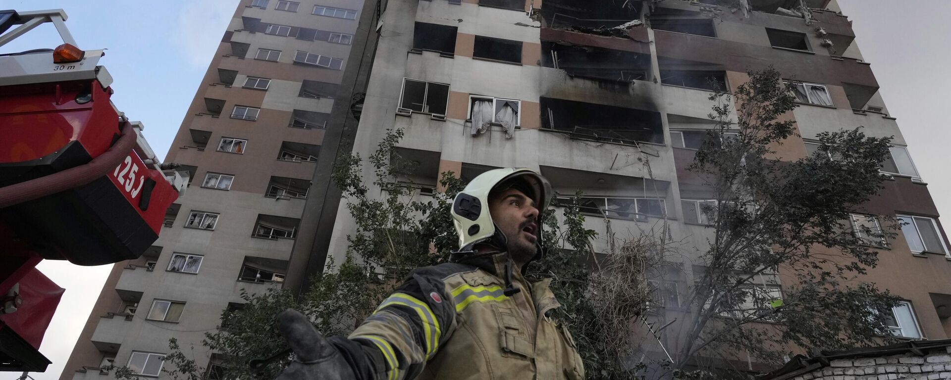 Un bombero llama a sus colegas en la escena de una explosión en un complejo residencial en el norte de Teherán, Irán, 13 de junio de 2025  - Sputnik Mundo, 1920, 06.07.2025
