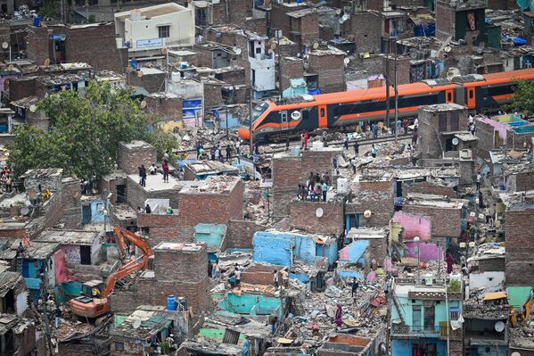 Un tren atraviesa una de las zonas de la capital india, Nueva Deli, en la que se está llevando a cabo una campaña de demolición de viviendas ilegales situadas cerca de las vías ferreas. - Sputnik Mundo