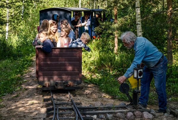 El ingeniero ruso Pável Chilin junto al mini ferrocarril que construyó personalmente en su parcela. Chilin tendió vías de 330 metros de longitud, además de construir un puente, una pequeña estación y la propia locomotora de vapor. - Sputnik Mundo