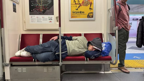 Un hombre sin hogar duerme en los asientos del metro en Toronto, Canadá - Sputnik Mundo