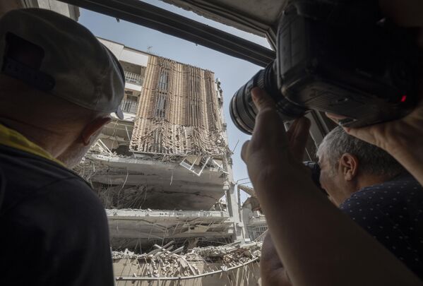 Fotoperiodistas iraníes toman fotografías de un edificio destruido por los ataques israelíes en una zona residencial del oeste de Teherán, Irán. Fotoperiodistas iraníes toman fotografías de un edificio destruido por los ataques israelíes en una zona residencial del oeste de Teherán, Irán. - Sputnik Mundo