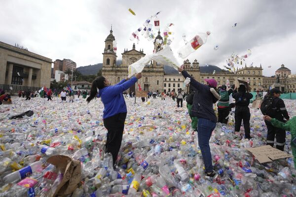 Recicladores lanzan botellas de plástico al aire en la plaza Bolívar de Bogotá, Colombia, mientras protestan por lo que consideran un precio demasiado bajo pagado por las empresas que compran materiales reciclados. Recicladores lanzan botellas de plástico al aire en la plaza Bolívar de Bogotá, Colombia, mientras protestan por lo que consideran un precio demasiado bajo pagado por las empresas que compran materiales reciclados. - Sputnik Mundo