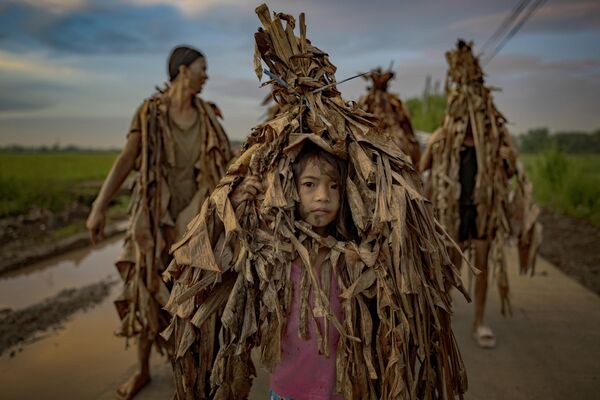 Los devotos del pequeño pueblo agrícola de Bibiclat celebran la fiesta de San Juan Bautista cubiertos de hojas de plátano y barro el 24 de junio de 2025 en el municipio de Aliaga, Filipinas.Este ritual, conocido como los Taong Putik (Gente del Barro), se celebra anualmente en esta pequeña aldea agrícola como una propia versión de la expresión de su fe y también para celebrar la fiesta de San Juan Bautista, a quien los supervivientes de la ocupación japonesa de 1944 rezaron para que lloviera y salvara a sus compatriotas. Un marcador cerca de la entrada de la iglesia del pueblo cuenta la historia de una fuerte lluvia torrencial que cayó este día y que obligó a los militares japoneses a suspender la ejecución de 14 aldeanos. Los devotos del pequeño pueblo agrícola de Bibiclat celebran la fiesta de San Juan Bautista cubiertos de hojas de plátano y barro el 24 de junio de 2025 en el municipio de Aliaga, Filipinas.Este ritual, conocido como los Taong Putik (Gente del Barro), se celebra anualmente en esta pequeña aldea agrícola como una propia versión de la expresión de su fe y también para celebrar la fiesta de San Juan Bautista, a quien los supervivientes de la ocupación japonesa de 1944 rezaron para que lloviera y salvara a sus compatriotas. Un marcador cerca de la entrada de la iglesia del pueblo cuenta la historia de una fuerte lluvia torrencial que cayó este día y que obligó a los militares japoneses a suspender la ejecución de 14 aldeanos. - Sputnik Mundo