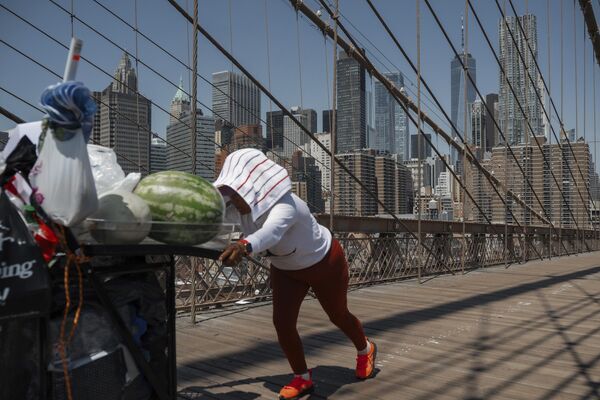 Una vendedora de fruta empuja su carrito en el puente de Brooklyn durante una ola de calor en Nueva York, EEUU. Una vendedora de fruta empuja su carrito en el puente de Brooklyn durante una ola de calor en Nueva York, EEUU. - Sputnik Mundo