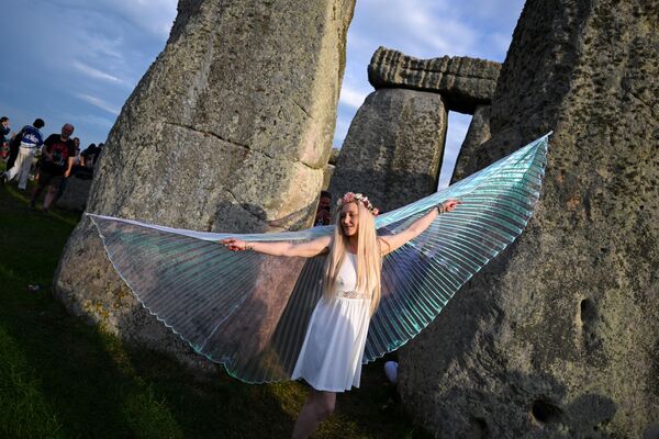 Visitantes disfrazados disfrutan del amanecer durante las celebraciones del solsticio de verano en Stonehenge, el 21 de junio de 2025 en Wiltshire, el Reino Unido. En el día más largo del año en el hemisferio norte, el sol sale en perfecta alineación con la Piedra del Talón y la Piedra del Altar del círculo de Stonehenge, de 5.000 años de antigüedad. Esta alineación demuestra la comprensión del calendario solar por parte de los antiguos constructores y sugiere que Stonehenge pudo servir de calendario o templo para fechas y acontecimientos importantes, una tradición que sigue marcándose cada año. Visitantes disfrazados disfrutan del amanecer durante las celebraciones del solsticio de verano en Stonehenge, el 21 de junio de 2025 en Wiltshire, el Reino Unido. En el día más largo del año en el hemisferio norte, el sol sale en perfecta alineación con la Piedra del Talón y la Piedra del Altar del círculo de Stonehenge, de 5.000 años de antigüedad. Esta alineación demuestra la comprensión del calendario solar por parte de los antiguos constructores y sugiere que Stonehenge pudo servir de calendario o templo para fechas y acontecimientos importantes, una tradición que sigue marcándose cada año. - Sputnik Mundo