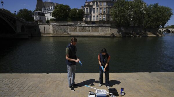 Mathias Haguet, a la izquierda, y Emilie Vilana, de Fluidion, analizan la calidad del agua del río Sena, el jueves 3 de julio de 2025, para la inauguración de las tres piscinas del Sena durante el evento Paris Plages, del 5 de julio al 31 de agosto en París. (Foto AP/Aurelien Morissard) - Sputnik Mundo
