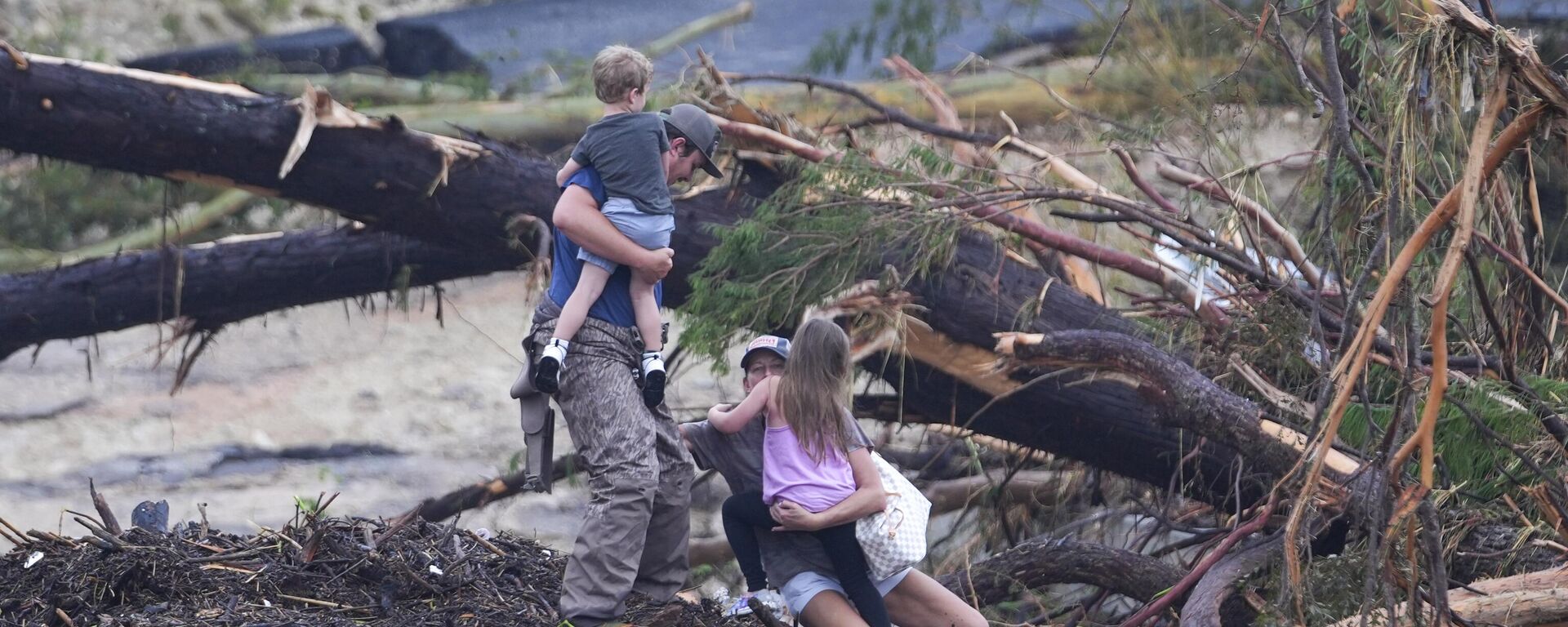 Люди переходят через реку Гуадалупе по обломкам моста после наводнения в Ингрэме, штат Техас - Sputnik Mundo, 1920, 06.07.2025
