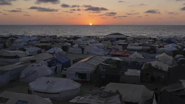 Un campamento de tiendas de campaña para palestinos desplazados se extiende cerca de la costa al atardecer en Khan Younis, Franja de Gaza, el miércoles 2 de julio de 2025. (Foto AP/Abdel Kareem Hana) - Sputnik Mundo