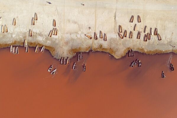 Barcos navegan por el lago Rosa, a unos 35 kilómetros de la ciudad Dakar, en Senegal. También conocido por su nombre local, Retba, el estanque ha recuperado su color tras un largo período de decoloración inducida por la contaminación. Se encuentra entre los lagos más salados del mundo y se vuelve rosa gracias a un alga llamada Dunaliella salina. - Sputnik Mundo
