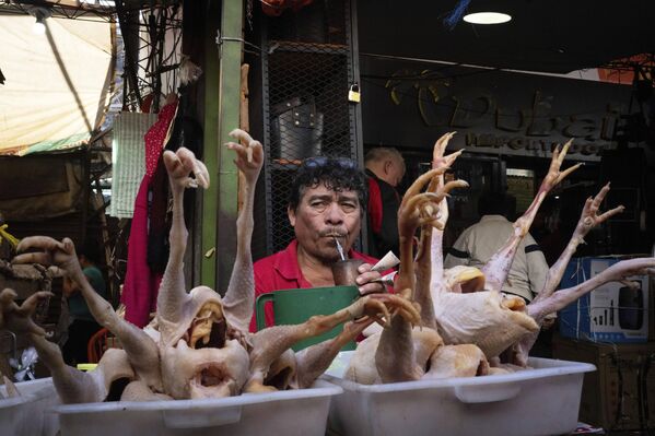 Un vendedor de pollos, Silvino, toma un tereré, una infusión de yerba mate servida fría, mientras espera a los clientes en el Mercado Nº4, en Asunción, Paraguay. - Sputnik Mundo