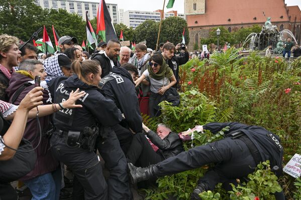Un agente de Policía detiene a un manifestante durante una protesta contra los ataques israelíes a Gaza mientras la gente se reúne para organizar una manifestación en Berlín. - Sputnik Mundo