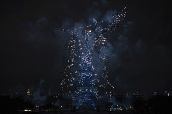Fuegos artificiales y drones iluminan la Torre Eiffel en París, durante las celebraciones del Día de la Bastilla el 14 de julio. - Sputnik Mundo