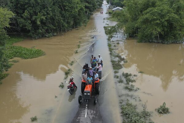 Residentes atraviesan las aguas inundadas en Bangladés.  La situación de las inundaciones en el país ha empeorado, ya que las nuevas aguas han inundado los upazilas de Chhagalnaiya y Feni Sadar, dejando a 150.000 personas sin hogar. - Sputnik Mundo