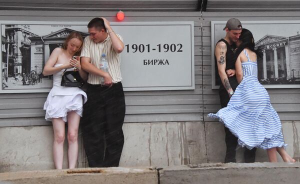 Los moscovitas se esconden de la lluvia. - Sputnik Mundo