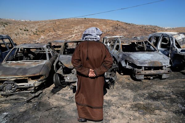 El terrateniente palestino Saber Asaleyeh, de 74 años, inspecciona su vertedero donde los automóviles quedaron incinerados durante un ataque nocturno por parte de colonos israelíes, informaron residentes locales en la localidad de Burqa, en Cisjordania. - Sputnik Mundo