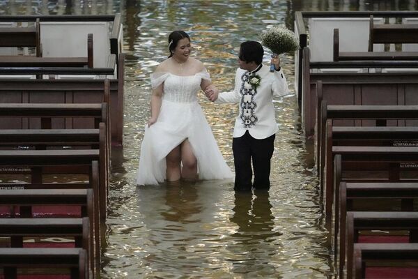 Recién casados celebran su boda en una iglesia inundada por las lluvias torrenciales en Filipinas. - Sputnik Mundo