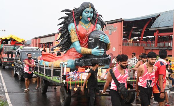 Creyentes de Shiva celebran la peregrinación conocida como Kanwariya y llevan agua del Ganges junto con una estatua en la capital india, Nueva Deli. - Sputnik Mundo