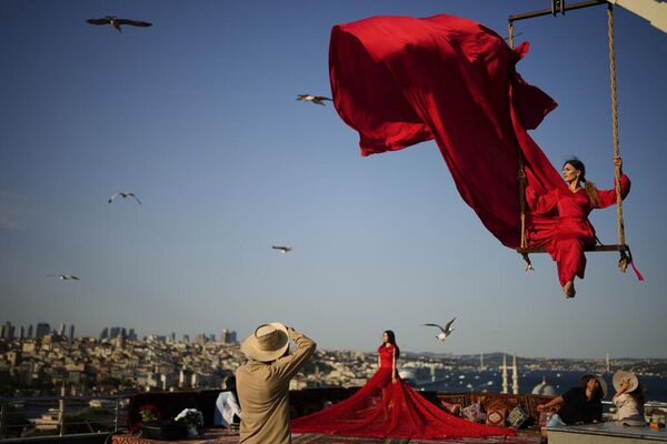 Turistas se sacan fotos en un estudio al aire libre con vista al estrecho del Bósforo en Estambul. - Sputnik Mundo