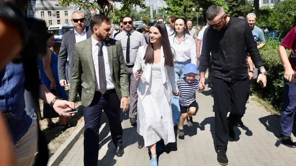 Evghenia Gutul, la jefa de la región autónoma de Gagaúzia, antes de una sesión de juicio, con su esposo y su hijo, el 5 de agosto, Chisináu, Moldovia - Sputnik Mundo