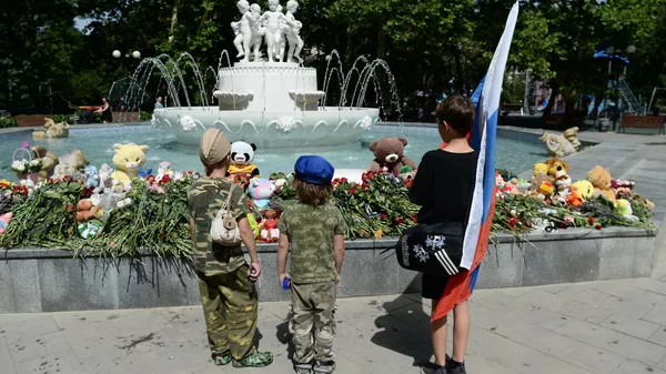 Niños cerca del monumento espontáneo en el parque Komsomolski en Sebastopol en el día de luto por los fallecidos en el ataque con misiles de las Fuerzas Armadas de Ucrania  - Sputnik Mundo