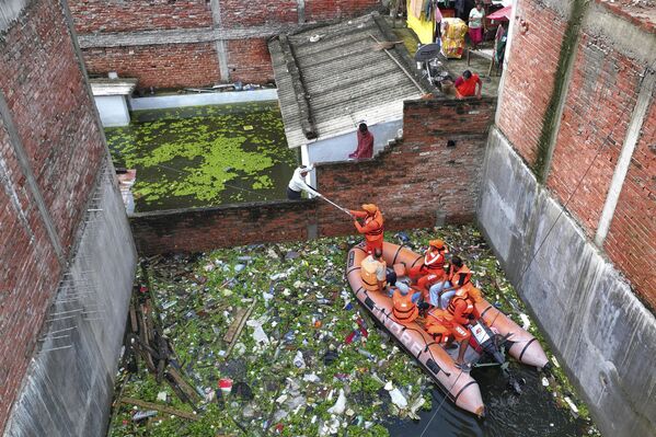 Empleados de los servicios de emergencia indios reparten alimentos a los habitantes afectados por las inundaciones tras las intensas lluvias monzónicas en las riberas del río Ganges. - Sputnik Mundo