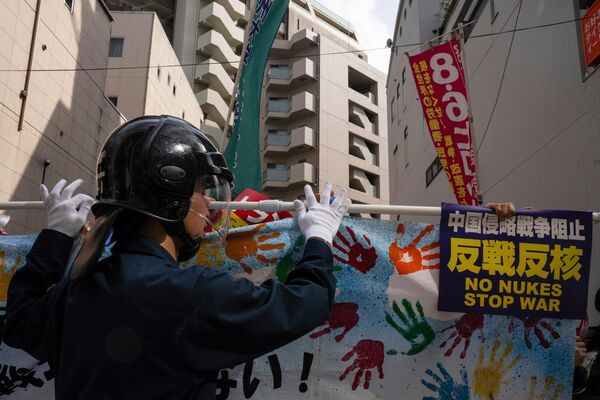 Policías vigilan una protesta con motivo del 80.º aniversario del bombardeo atómico de Hiroshima, Japón. - Sputnik Mundo