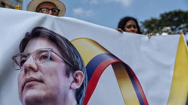 Personas sostienen pancartas del precandidato presidencial Miguel Uribe Turbay, fallecido a raíz de un atentado - Sputnik Mundo