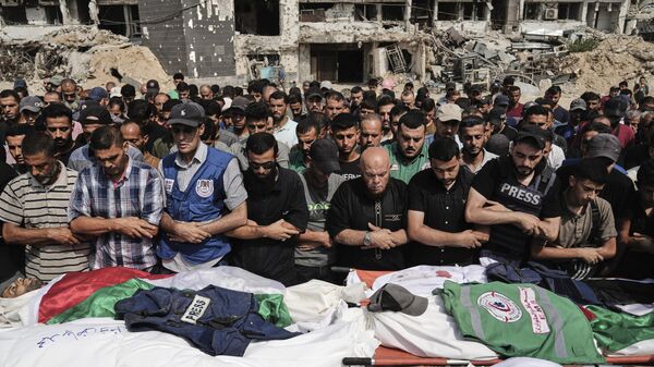 Palestinos rezan ante los cuerpos de periodistas, incluidos los corresponsales de Al Jazeera Anas al-Sharif y Mohamed Qreiqeh, quienes fueron asesinados por Israel mediante un ataque aéreo - Sputnik Mundo