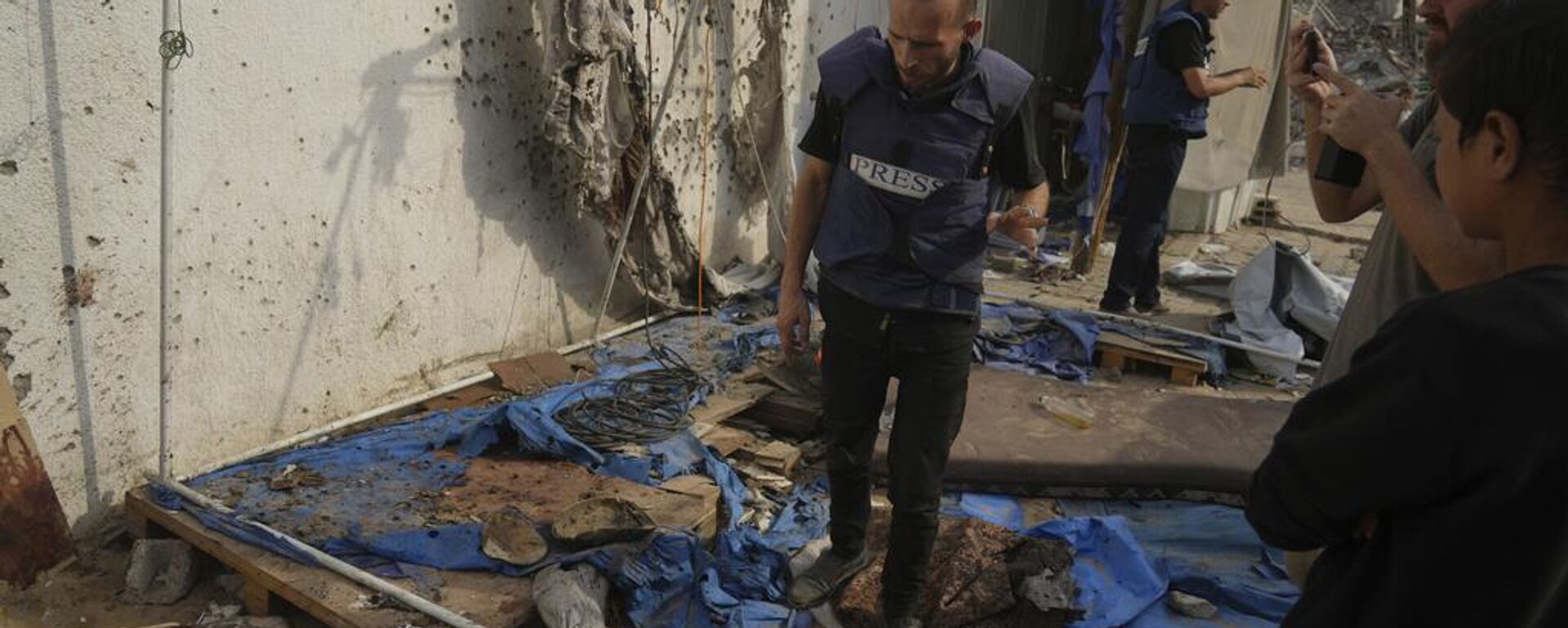Periodistas palestinos inspeccionan la carpa destruida donde periodistas, incluidos los corresponsales de Al Jazeera Anas al-Sharif y Mohamed Qureiqa, fueron asesinados por Israel - Sputnik Mundo, 1920, 17.08.2025
