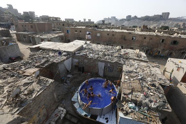 Niños nadando en una piscina instalada en la azotea de un edificio en la ciudad egipcia de El Cairo. - Sputnik Mundo