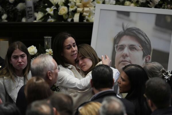 La esposa del asesinado candidato presidencial y senador Miguel Uribe abraza a una de sus hijas durante una ceremonia en el Parlamento colombiano. - Sputnik Mundo