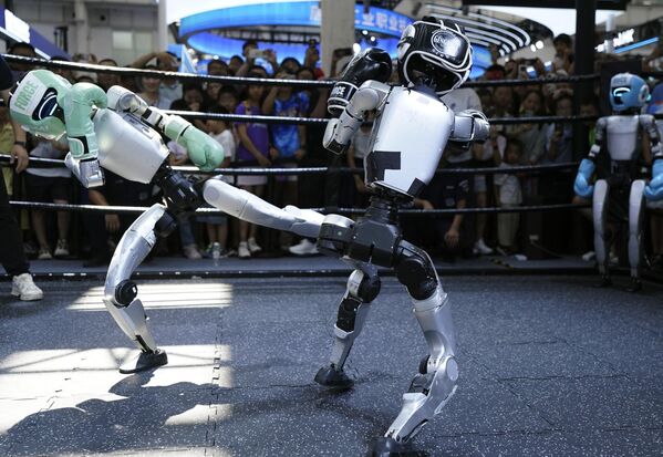 Robots humanoides de la empresa Unitree Robotics compiten en un combate de boxeo en la Conferencia Mundial de Robótica celebrada en Pekín. - Sputnik Mundo