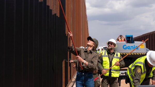 Kristi Noem, secretaria de Seguridad Nacional de EEUU, pintando el muro fronterizo con México - Sputnik Mundo