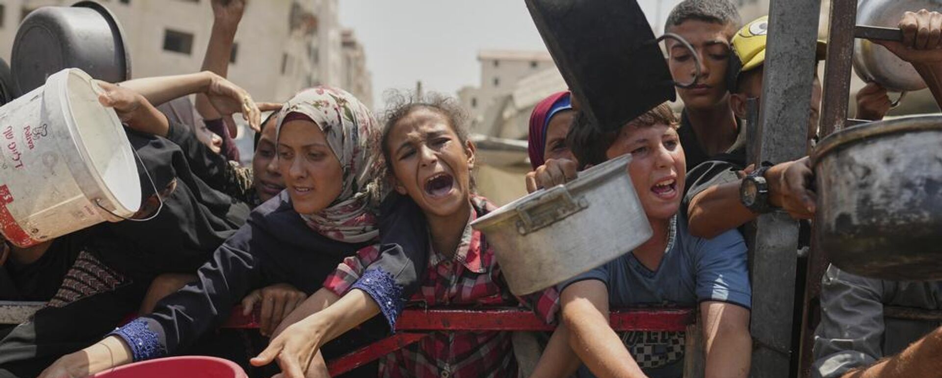 Los palestinos luchan por conseguir alimentos donados en una cocina comunitaria en la ciudad de Gaza, al norte de la Franja de Gaza  - Sputnik Mundo, 1920, 22.08.2025