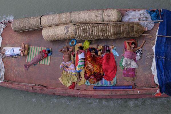 Los comerciantes duermen en un barco mientras se dirige al mercado mayorista en Daca, Bangladés. - Sputnik Mundo