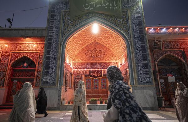 Mujeres iraníes con velo caminan en un lugar sagrado en la ciudad de Astaneh-ye Ashrafiyeh, Irán.  La zona fue atacada por el Ejército israelí el último día del conflicto de 12 días con Israel.  - Sputnik Mundo